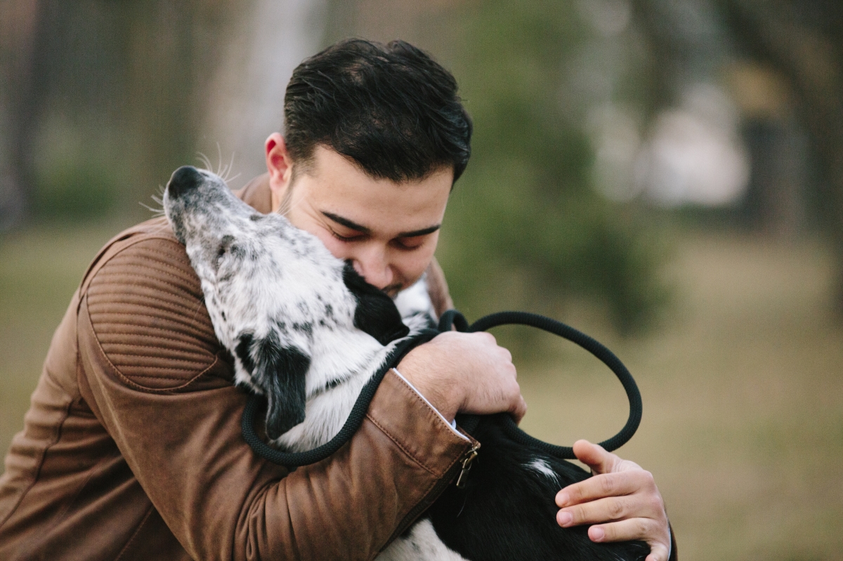 man hugging dog