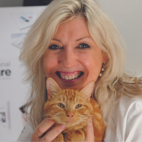 Woman holding a cat posing for the camera