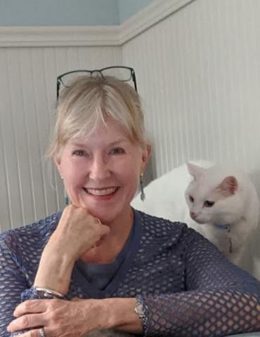 a woman with a cat smiling for the camera